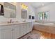 Bathroom features a double sink vanity, soaking tub, and natural light at 5090 S Perry Park Rd, Sedalia, CO 80135