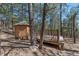 Cozy wooden cabin featuring an outdoor patio, surrounded by lush trees at 5090 S Perry Park Rd, Sedalia, CO 80135