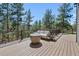 Relaxing deck with outdoor furniture, views of surrounding trees and a stylish fire pit at 5090 S Perry Park Rd, Sedalia, CO 80135