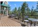 Expansive wooden deck offering serene views, with stylish chairs and railings overlooking the trees at 5090 S Perry Park Rd, Sedalia, CO 80135