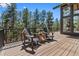 Spacious outdoor deck with comfortable seating and views of the surrounding trees at 5090 S Perry Park Rd, Sedalia, CO 80135