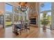 Dining room featuring large windows, chandelier, wood floors, and stone fireplace at 5090 S Perry Park Rd, Sedalia, CO 80135