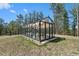 Charming greenhouse bathed in sunlight, surrounded by lush greenery and a manicured lawn at 5090 S Perry Park Rd, Sedalia, CO 80135