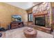 Inviting living room with a stone fireplace, TV, and warm, textured walls at 5090 S Perry Park Rd, Sedalia, CO 80135