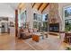 Bright living room featuring a stone fireplace, large windows, and hardwood floors at 5090 S Perry Park Rd, Sedalia, CO 80135