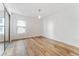 Bright bedroom with hardwood floors, a modern pendant light, and large window with building views at 2 Adams St # 608, Denver, CO 80206