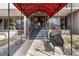 Elegant building entrance with a red awning, stone pathway, landscaping, and a bench at 2 Adams St # 608, Denver, CO 80206