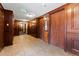 Hallway with elevator access and dark paneled wood walls and tile floors at 2 Adams St # 608, Denver, CO 80206