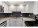 Well-maintained kitchen with white cabinets, stainless steel appliances, and black mosaic backsplash at 2 Adams St # 608, Denver, CO 80206