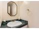 Small bathroom with pedestal sink, green countertop and octagonal mirror at 3242 S Heather Gardens Way, Aurora, CO 80014