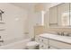 Clean bathroom with white vanity, shower, and updated hexagonal tile at 3242 S Heather Gardens Way, Aurora, CO 80014