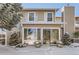 Townhouse with sunroom and snow-covered landscaping at 3242 S Heather Gardens Way, Aurora, CO 80014