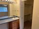 Bathroom vanity with a large mirror, good lighting and an organized closet for storage and organization at 2043 S Salida St, Aurora, CO 80013
