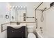 Well-lit bathroom with a vanity, a shower-tub combo with accessibility features, and a mirrored cabinet at 735 S Clinton St # 5B, Denver, CO 80247