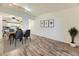 Open concept dining room featuring laminate wood flooring, modern lighting, and three art pieces at 735 S Clinton St # 5B, Denver, CO 80247