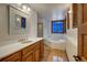 Well-lit bathroom featuring a corner bathtub, tiled flooring, and a vanity with a marble countertop at 127 Marks Ln, Breckenridge, CO 80424