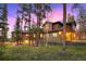 Picturesque home featuring a stone facade and warm lighting amidst towering trees and twilight at 127 Marks Ln, Breckenridge, CO 80424