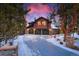 Charming exterior featuring a three-car garage and stone facade with a sky painted in hues of pink and blue at 127 Marks Ln, Breckenridge, CO 80424