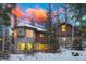 Exterior view displaying a stunning home with stone accents, large windows, and a vibrant sunset sky at 127 Marks Ln, Breckenridge, CO 80424