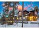 Exterior view of a home with stone and wood facade, with the warm glow of interior lighting creating a welcoming atmosphere at 127 Marks Ln, Breckenridge, CO 80424