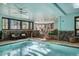 Inviting indoor pool area with a gym, stone details, and natural light at 127 Marks Ln, Breckenridge, CO 80424