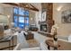 Inviting living room featuring a stone fireplace, high ceilings, hardwood floors, and picturesque mountain views at 127 Marks Ln, Breckenridge, CO 80424