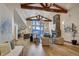 Bright living room with high ceilings, wooden beams, stone fireplace, hardwood floors, and mountain views at 127 Marks Ln, Breckenridge, CO 80424