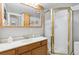 Bathroom with a white vanity, sink, mirror and glass shower enclosure with gold trim at 9431 Crossland Way, Highlands Ranch, CO 80130