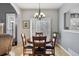 Dining room with hardwood floors and a round wooden table; modern chandelier and plantation shutters at 9431 Crossland Way, Highlands Ranch, CO 80130
