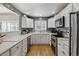 Well-lit kitchen features quartz counters, stainless steel appliances, and sleek cabinets at 9431 Crossland Way, Highlands Ranch, CO 80130