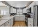 Modern kitchen boasts white cabinets, stainless steel appliances, and bright, natural light at 9431 Crossland Way, Highlands Ranch, CO 80130