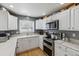 Modern kitchen features white cabinets, stainless appliances, and lots of countertop space at 9431 Crossland Way, Highlands Ranch, CO 80130