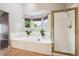 Luxurious main bathroom featuring a shower, a soaking tub, and large windows with patterned window treatments at 20304 Vista Cir, Parker, CO 80138