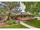 Private backyard with a brick home, mature trees, and a cozy patio perfect for relaxation and entertaining at 9650 W 35Th Ave, Wheat Ridge, CO 80033