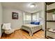 Bright bedroom with hardwood floors, corner windows with sheer curtains, and shelving at 9650 W 35Th Ave, Wheat Ridge, CO 80033