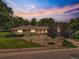 Charming brick home boasts well-maintained landscaping, rock garden, and mature trees under a vibrant sky at 9650 W 35Th Ave, Wheat Ridge, CO 80033