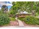 Charming home with a well-manicured lawn, mature trees and a stone walkway leading to the entrance at 9650 W 35Th Ave, Wheat Ridge, CO 80033