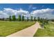 Picturesque park view with a paved path, mature trees, and inviting benches at 9650 W 35Th Ave, Wheat Ridge, CO 80033