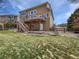 Backyard with a spacious deck, a well-manicured lawn, and mature trees for privacy and shade at 23559 Branston Ln, Parker, CO 80138