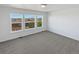 Bright bedroom boasts three large windows, gray carpet, and neutral paint for a comfortable space at 23559 Branston Ln, Parker, CO 80138