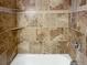 Close-up of tiled shower with built-in shelves and hand-held shower head at 23559 Branston Ln, Parker, CO 80138