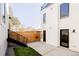 Private backyard with a concrete patio, wooden fence, and modern townhouse exterior at 3437 W 17Th Ave, Denver, CO 80204