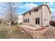 Backyard featuring concrete patio with decorative stone planter and adjacent home at 13915 Ivanhoe St, Thornton, CO 80602