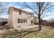 Landscaped backyard with concrete patio, mature tree, and view of neighboring homes at 13915 Ivanhoe St, Thornton, CO 80602