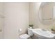 Clean half-bathroom featuring a pedestal sink, oval mirror, and neutral tones, complete with stylish plant accents at 13915 Ivanhoe St, Thornton, CO 80602