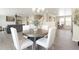 Open dining room featuring a stylish chandelier and convenient access to the living room and kitchen at 13915 Ivanhoe St, Thornton, CO 80602