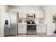 Well-lit kitchen with stainless steel appliances, sleek countertops, and white cabinetry at 13915 Ivanhoe St, Thornton, CO 80602