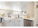 Modern kitchen featuring white cabinets and quartz countertops with an undermount sink and stainless dishwasher at 13915 Ivanhoe St, Thornton, CO 80602