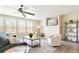 Bright living room featuring modern ceiling fan, plush seating, a stylish area rug, and abundant natural light at 13915 Ivanhoe St, Thornton, CO 80602