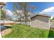 Large backyard with a storage shed, mature tree, and a pristine lawn at 13244 Quivas St, Denver, CO 80234